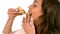 Casual woman eating slice of pizza