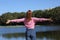 Casual woman stretching arms celebrating vacation in a lake