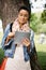 Casual woman using tablet PC outdoors