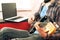 Casually dressed young man with guitar playing songs in the room at home. Online guitar lessons concept. Male guitarist practicing