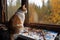 cat artist sitting on high perch, painting view of forest with intricate brushstrokes