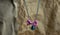 Cat collar with pink bow, blue bell, silver string, placed on wrinkled brown paper. disorganized some part in blur