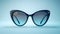 Cat eye glasses on blue surface, eye glass accessory in azure