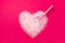 Cat litter, heart shaped bright pink background with a spatula for cleaning poop. Concept for labels, packaging advertising of the