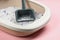 Cat litter tray with filler and scoop on pink background, closeup