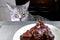 Cat looks irritably over at food. The pet is angry at a piece of fried meat. Grey cat peers into BBQ beef. Cooked meat on white