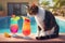 A cat sips on a tiny, colorful mocktail by the pool