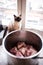 Cat sitting next to a kettle with meat