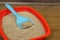 Cat tray with clumping litter and scoop on floor, closeup