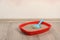 Cat tray with clumping litter and scoop on floor near pink wall. Space for text