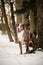 Catahoula Leopard Dog is standing under the pine in snow.