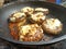 Catalimized onion beef burger with pickled onion and chive cheddar cheese cooking in a non stick pan