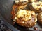 Catalimized onion beef burger with pickled onion and chive cheddar cheese cooking in a non stick pan