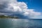 Catamaran by the coastline over dramatic sky