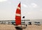 Catamaran with a sail moored on a secluded beach