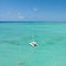 Catamaran sailing boat in turquoise sea lagoon on tropial Mauritius island. Aerial, drone view.
