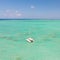 Catamaran sailing boat in turquoise sea lagoon on tropial Mauritius island. Aerial, drone view.