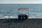 Catamaran on the seashore. Waves of the sea surf on the stone beach.