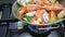 Cataplana with fresh seafood, vegetables is cooked on a gas stove, boiling very much. Horizontal video. Close-up.