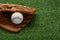 Catcher`s mitt and baseball ball on green grass, space for text. Sports game
