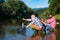 Catching fish. Two men friends fisherman fishing on river. Old father and son with rod fishing at riverside