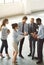 Catching up in the office lobby. High angle shot of a group of businesspeople talking together while standing in an