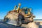 Caterpillar crawler heavy duty dozer with metal shovel blade in sand