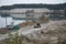 Caterpillar loader and dump truck works at the opencast mining quarry. Heavy machinery in the open pit at river. Dozer and truck