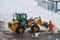 Caterpillar wheel loader with a snowplow plowing snow during a blizzard