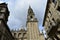 Cathedral. Baroque clock tower in romanesque facade, clean stone. Santiago de Compostela, Spain. Platerias, rainy day, grey sky.