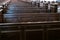 Cathedral benches. Rows of pews in christian church. Heavy solid uncomfortable wooden seats