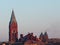 Cathedral on blue sky background and house roofs