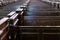 Cathedral pews. Rows of benches in christian church. Heavy solid uncomfortable wooden seats