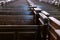 Cathedral pews. Rows of benches in christian church. Heavy solid uncomfortable wooden seats