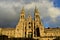 Cathedral with sunset light. Obradoiro Square, rainy day, grey sky. Baroque facade and towers, Santiago de Compostela, Spain.