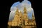 Cathedral with sunset light, view from Town Hall arch. Obradoiro Square, rainy day, grey sky. Baroque facade and towers, Santiago