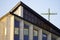 Catholic Church building in modern style, Catholic cross, modern architecture, stained glass, TV antenna on the roof