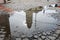 Catholic church reflected in a puddle on cobblestone road