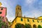 Catholic Church of San Giovanni Battista chiesa with clock tower, colorful buildings houses and flowers around in Monterosso villa