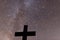 Catholic cross on focus, fragment of the Milky Way