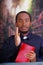 Catholic priest wearing traditional clerical collar shirt sitting and holding bible looking into camera, religion