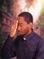 Catholic priest wearing traditional clerical collar shirt standing performing sign of the cross and holding rosary in