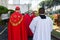 Catholic priests walk towards an open-air Palm Sunday mass