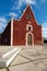 Catholic red colonial church Itzimna in a park, Merida, Yucatan, Mexico