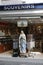 Catholic souvenir shop on the streets of Lourdes. Large statue of the Virgin Mary at the entrance