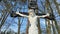 Catholicism and Christianity concept. Religious symbol. Cross and Jesus Christ statue on spring forest background.Easter