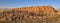 Cattle feeders and a row of round hay bales