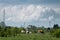 Cattle in pasture against transmission line and enormous cloud