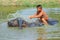 Cattleboy without shirt bathing buffalo