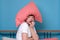 Cauacsian young man with pillow on head in bed being afraid